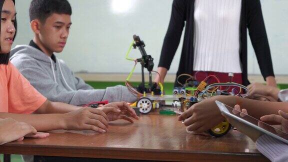 科学和技术课堂中学水平:老师解释如何操作一个机器人程序给孩子们