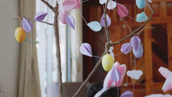 五颜六色的复活节彩蛋挂在树枝上用花环装饰复活节假期