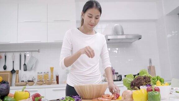 年轻的亚洲女人在厨房做沙拉健康食品美丽的女性在随意使用有机蔬菜大量营养准备沙拉在家里适合身体健康食品