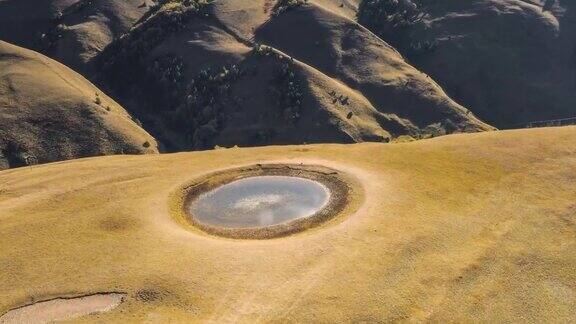 一个圆形的湖镶嵌在高山草甸上