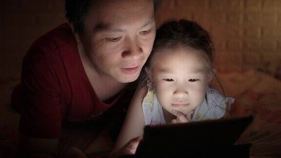 父亲和女儿在家里使用平板电脑学习