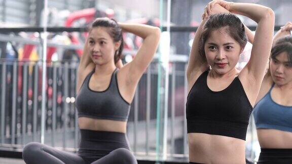 一组运动的年轻亚洲妇女在运动服热身与体操和伸展运动锻炼前的重量训练健康的健美运动员builder肌肉的生活理念