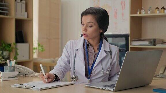 女医生与病人网上会诊后填写医疗卡