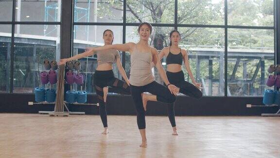 年轻的亚洲体育有吸引力的人练习瑜伽课与教练亚洲女性群体在健身室锻炼健康的生活方式体育活动体操或芭蕾课
