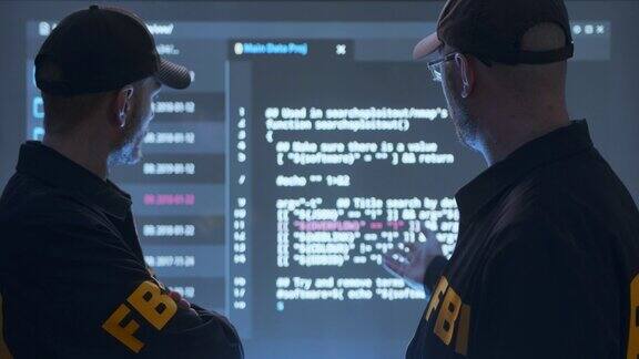 FBI探员在带有代码的巨大未来感HUD屏幕前工作