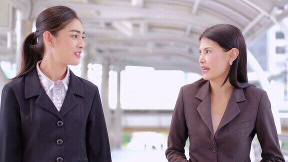 两个亚洲女商人一边走一边聊天