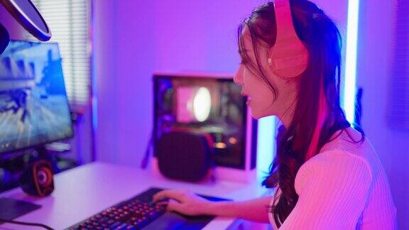 亚洲美丽的电子竞技女玩家在电脑上玩在线视频游戏有吸引力的年轻女孩游戏玩家感到快乐享受技术直播而在家里玩网络比赛