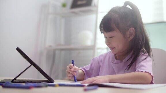 女孩在家里用数字平板电脑学习电子学习课程