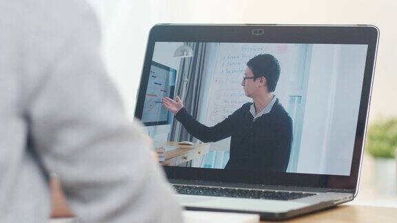 年轻的亚洲少女大学学生使用笔记本电脑远程教学与男教师远程教学在家里的互联网