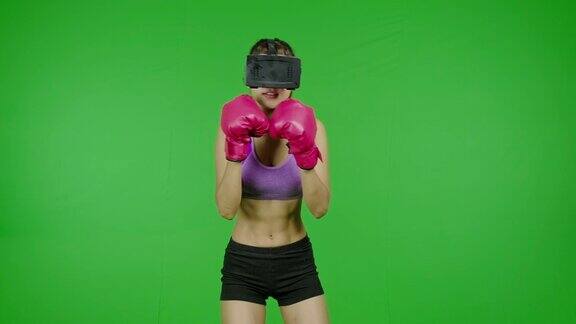 适合女性拳击使用VR头盔在绿色屏幕上钩和刺色度键技术增强现实亚洲妇女用于图形覆盖和剪切的目的