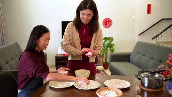 两位亚洲妇女正在做汤圆作为中国新年的团圆饭