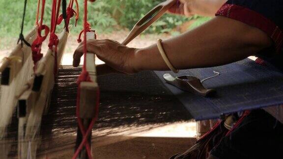 传统纺织业在手工艺村妇女在木制织布机上工作纺纱制造丝绸或棉织品泰国的丝织
