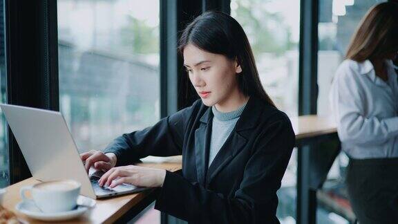 年轻的女商人使用笔记本电脑在咖啡店工作