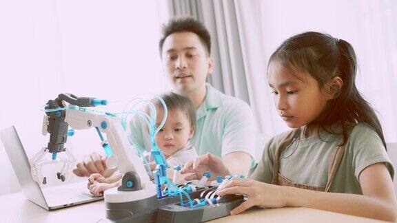 亚洲父母通过计算机编程教育科学技术液压概念教女儿基本控制机器人手臂在家在线学习