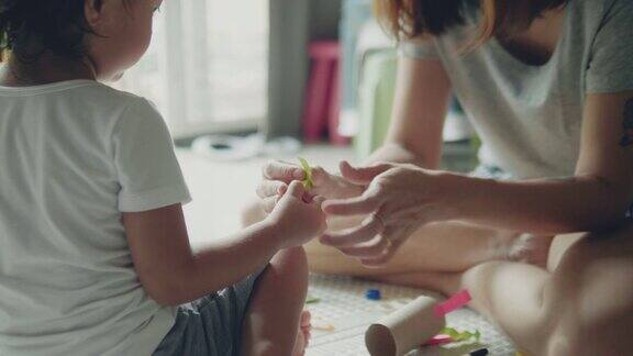 年轻的亚洲母亲和儿子用纸工艺品制作玩具
