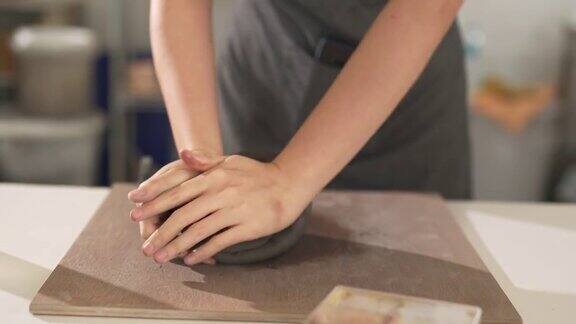 4K特写女手雕刻家在桌上捏粘土制作陶瓷雕塑
