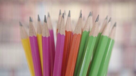 多色铅笔的黑碳石墨、尖点或固体颜料芯的宏观特写铅笔显示木纤维防止笔尖折断在一个小罐子里旋转铅笔