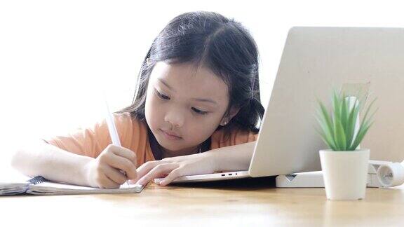 亚洲女孩在COVID-19期间在家学习电子学习生活方式概念