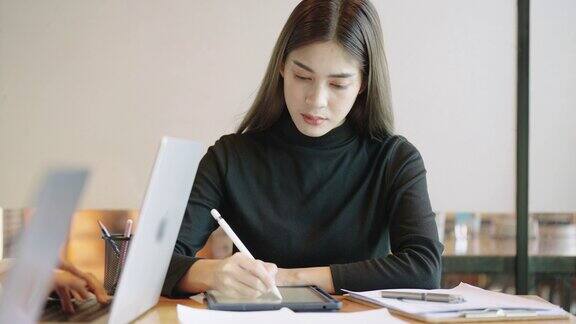 亚洲学生十几岁的女性正在使用平板电脑在一所大学的教室里在线学习教育技术