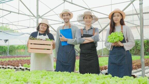 亚洲农民在蔬菜水培农场工作的肖像小组迷人的年轻农业男女感到自豪和自信的工作后在温室与幸福然后看着相机