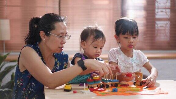 亚洲家庭坐在家里的客厅里一起玩玩具