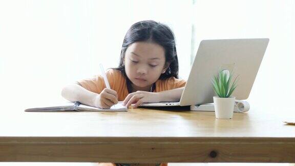 亚洲女孩在COVID-19期间在家学习电子学习生活方式概念