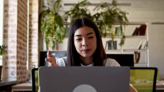 千禧年亚洲女孩用笔记本电脑进行视频会议