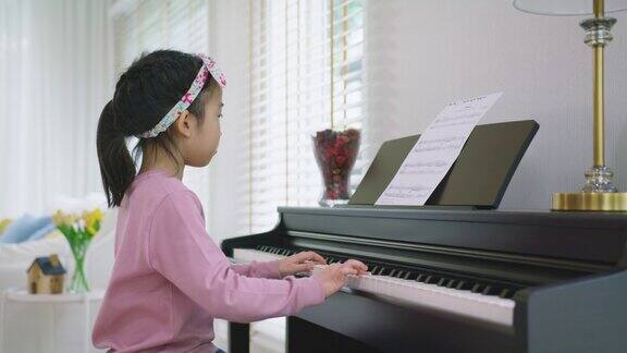 年轻可爱的亚洲小孩显示音乐技能在家庭学校班