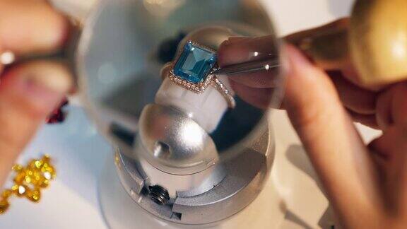 珠宝商、金匠在珠宝工作室使用放大镜和工具制作戒指