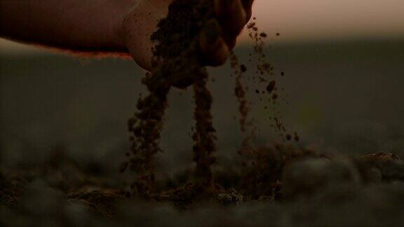 日落时分农夫的手在田里铲土