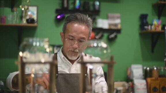 亚洲华人高级男咖啡师在咖啡店准备冰滴咖啡