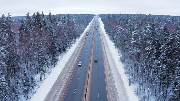 黑色和白色的汽车行驶在白雪覆盖的森林中央的道路上