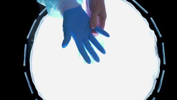 医生在手术室里戴上蓝色医用手套护士保护她的手
