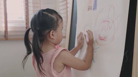 亚洲小女孩用彩笔在纸上画画