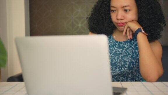亚洲失业妇女使用笔记本电脑和智能手机在家里找新工作自由职业者在家远程在线工作4k慢动作
