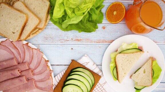 做三明治的桌子上满是食物的早餐和吃-停止运动