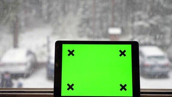 数字平板电脑在下雪的窗口
