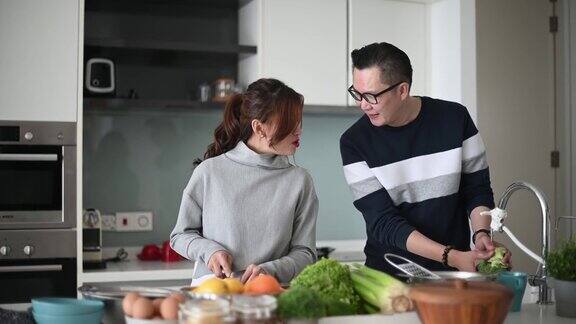 亚洲华人夫妇一起在厨房柜台准备食物在周末聚在一起