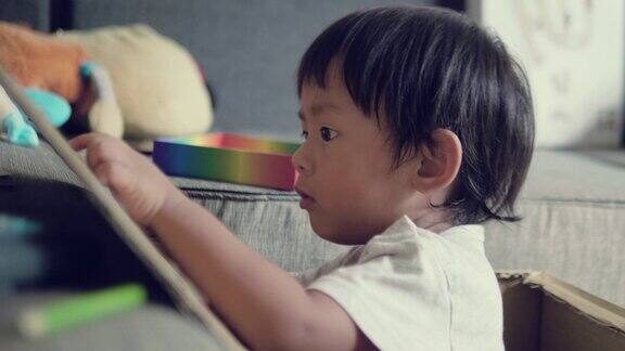 亚洲男婴正在纸板上画素描