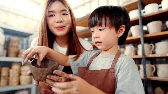 快乐的幼儿肖像享受与母亲与粘土工作