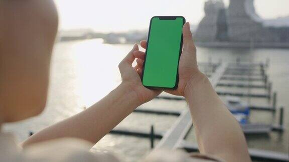 绿屏手持智能手机上的女人