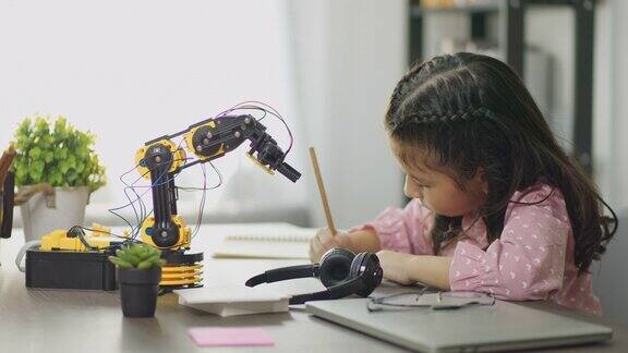 女孩在家里学习控制机械臂科学课程