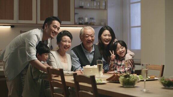 快乐的亚洲家庭坐在餐桌前合影