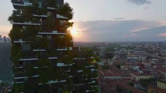 夕阳下城市的鸟瞰图向后揭示高大的现代公寓与绿色植物的外立面米兰意大利