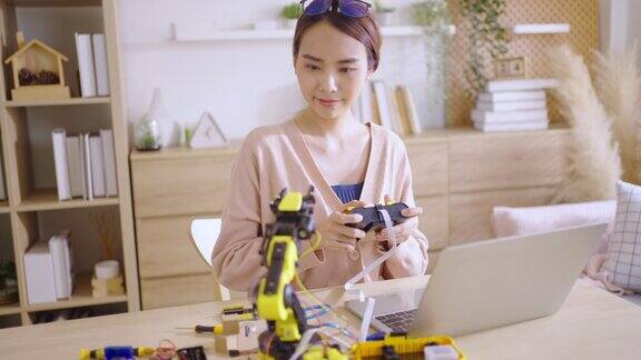 年轻的亚洲女工程师程序员正在家里做一个机器人项目