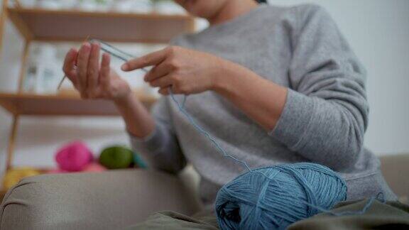 女性在家中客厅放松时的手编织钩针特写