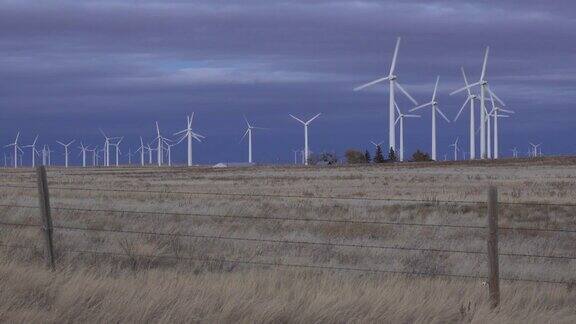 科罗拉多州波尼国家草原上旋转的风力涡轮机上的落日