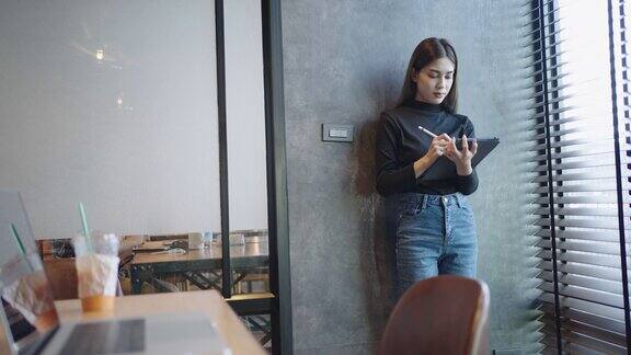 亚洲学生十几岁的女性正在使用平板电脑在一所大学的教室里在线学习教育技术