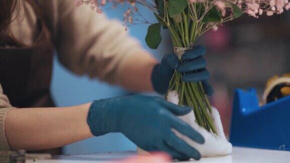 特写亚洲华人女花匠小企业主在花店包装插花花束经营小生意的日常生活