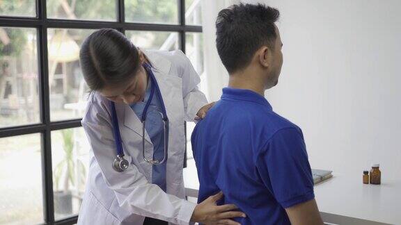 女医生为男病人进行举手理疗亚洲女理疗师在诊所工作帮助保护病人的手病人做伸展运动